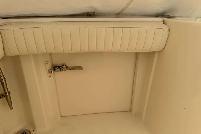 Slide: The Image of 2008 Henriques 30 Express boat interior with cushioned seating and storage compartment. - 11