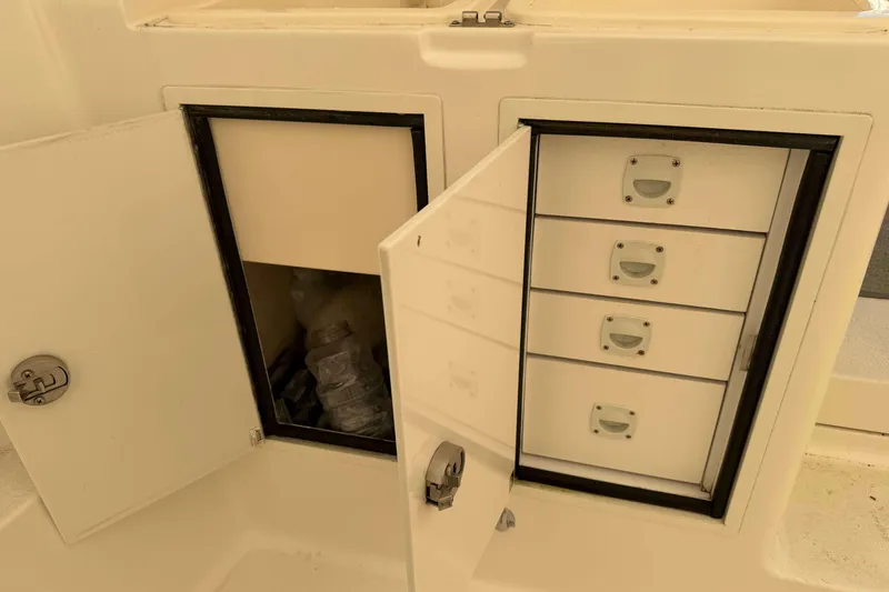 Slide: The Image of Storage compartments on a 2008 Henriques 30 Express boat, featuring drawers and a cabinet. - 28