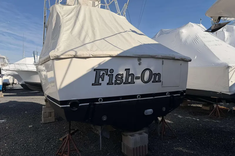 Slide: The Image of 2008 Henriques 30 Express boat named "Fish-On" covered and stored outdoors. - 3