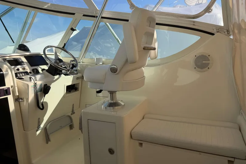 Slide: The Image of 2008 Henriques 30 Express boat cockpit with steering wheel and captain's chair. - 32