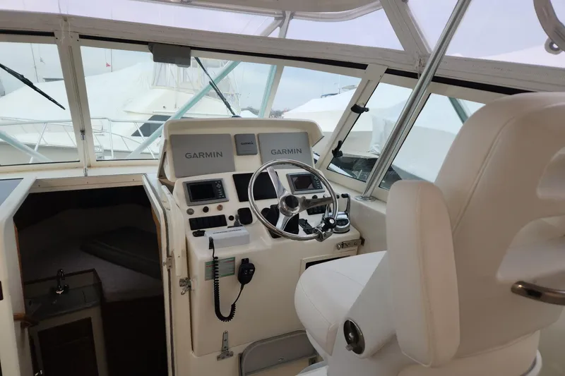 Slide: The Image of 2008 Henriques 30 Express boat cockpit with Garmin navigation system and white seating. - 34