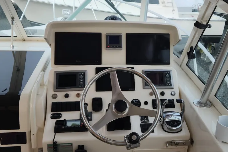 Slide: The Image of 2008 Henriques 30 Express boat helm with steering wheel and navigation controls. - 36