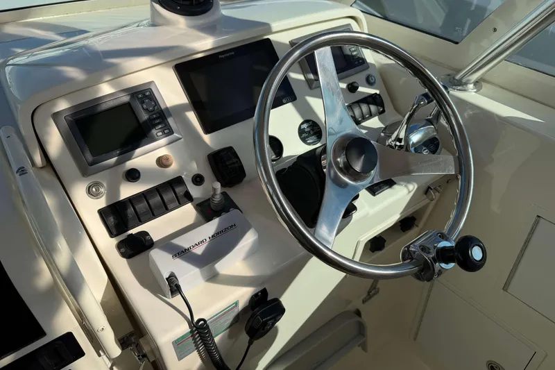 Slide: The Image of 2008 Henriques 30 Express boat dashboard with steering wheel and navigation controls. - 39