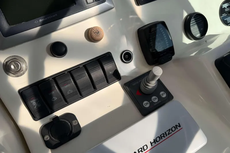 Slide: The Image of Control panel of a 2008 Henriques 30 Express boat with switches and joystick. - 40