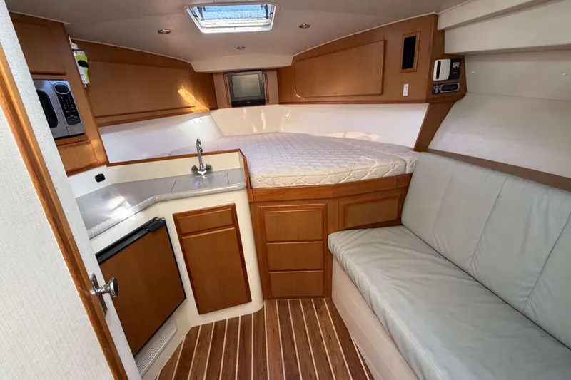 Slide: The Image of 2008 Henriques 30 Express cabin interior with bed, kitchenette, and seating area. - 50