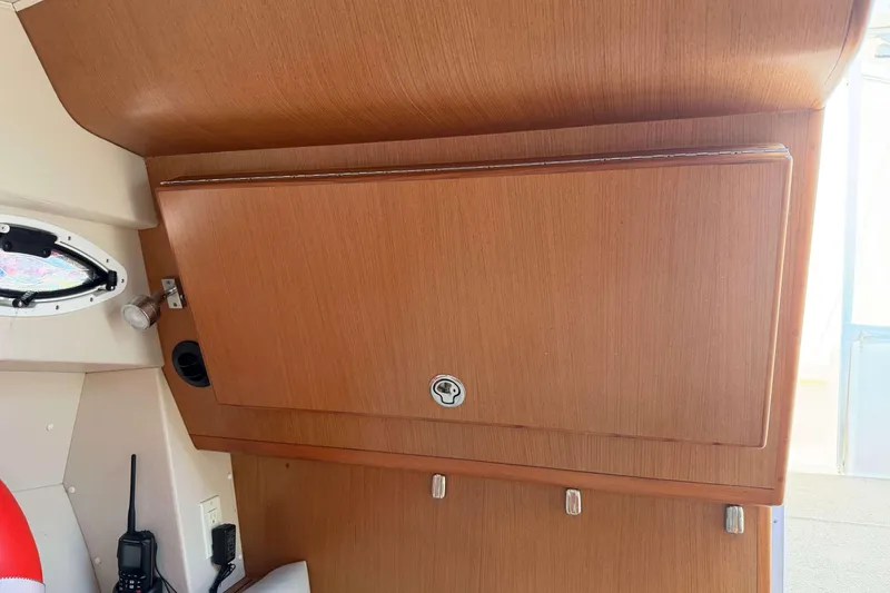 Slide: The Image of Interior of 2008 Henriques 30 Express boat with wooden cabinetry and porthole window. - 54