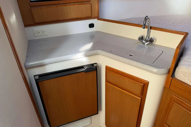 Slide: The Image of 2008 Henriques 30 Express boat interior with kitchenette, sink, and mini fridge. - 56