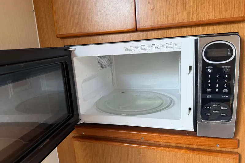 Slide: The Image of Open microwave in 2008 Henriques 30 Express boat kitchen, showing control panel and interior. - 59