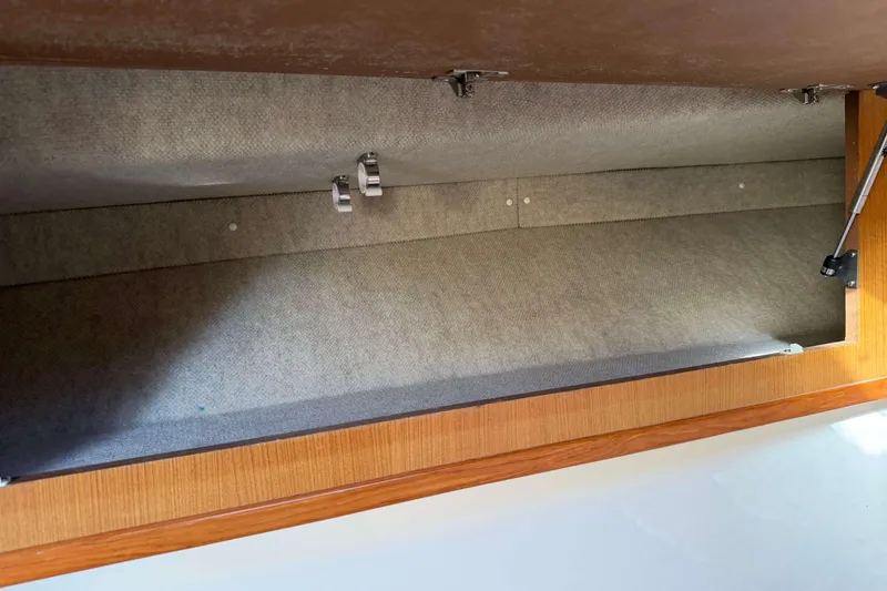 Slide: The Image of Interior storage compartment of 2008 Henriques 30 Express boat, featuring wood and fabric lining. - 64