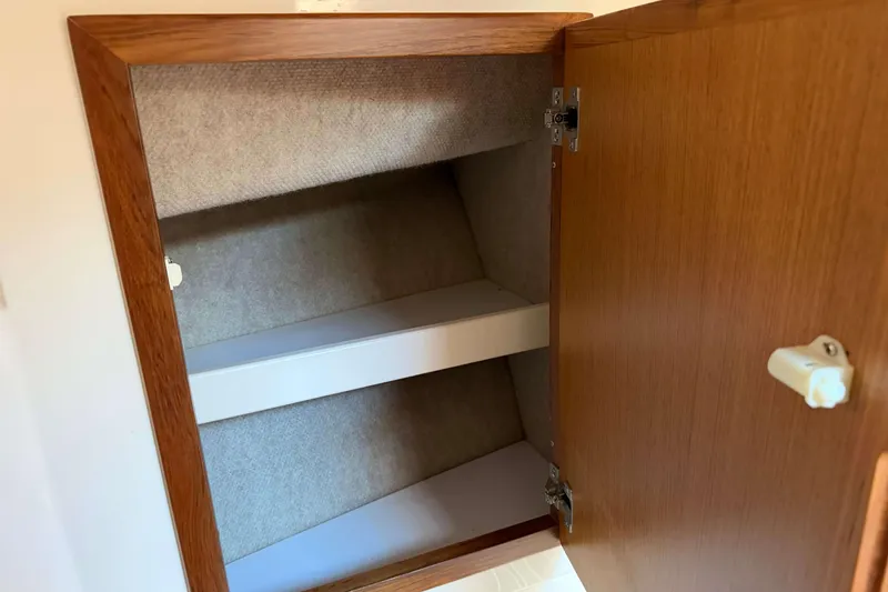 Slide: The Image of Open wooden cabinet with shelves inside a 2008 Henriques 30 Express boat. - 71
