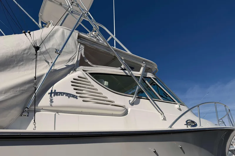 Slide: The Image of 2008 Henriques 30 Express boat with covered deck against clear blue sky. - 96