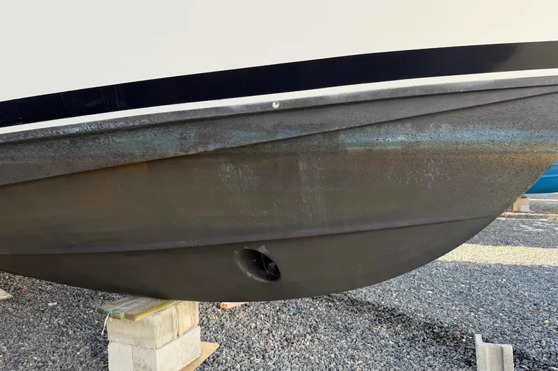 Slide: The Image of 2008 Henriques 30 Express boat hull on blocks, showing wear and marine growth. - 99