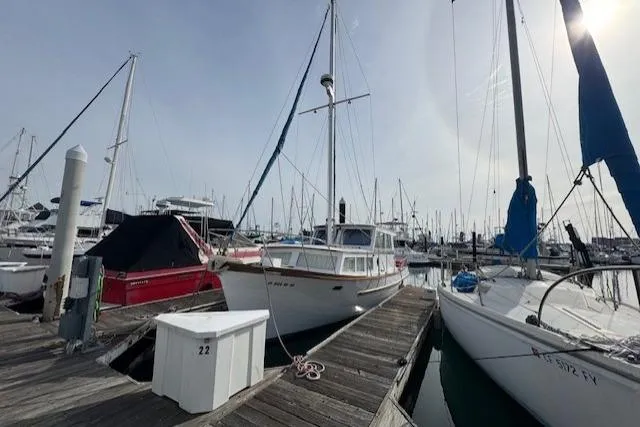 The Image of 1980 Roughwater MOTOR SAILER docked at marina, surrounded by other boats. - 0