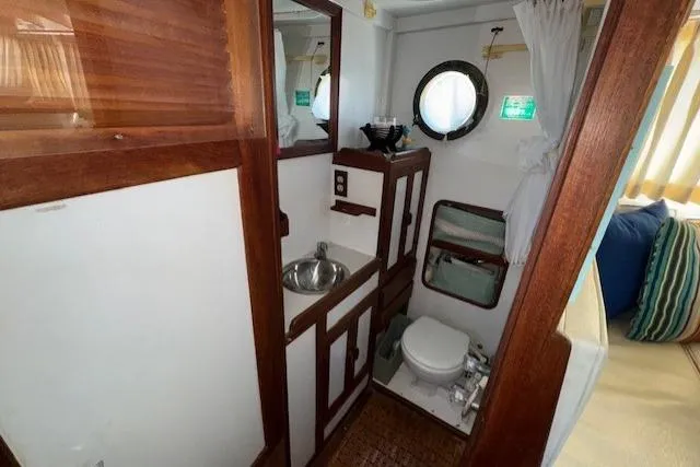 Slide: The Image of 1980 Roughwater MOTOR SAILER bathroom with wooden accents and nautical decor. - 12