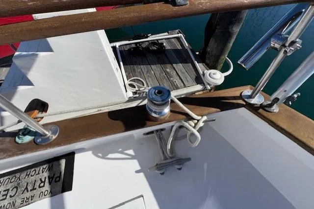 Slide: The Image of 1980 Roughwater MOTOR SAILER docked, featuring a striped canopy and marina view. - 16