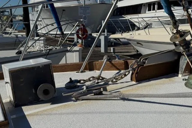 Slide: The Image of 1980 Roughwater MOTOR SAILER deck with anchor chain and marina background. - 24