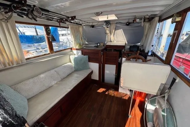 Slide: The Image of 1980 Roughwater MOTOR SAILER interior with wooden flooring, cushioned seating, and helm station. - 3