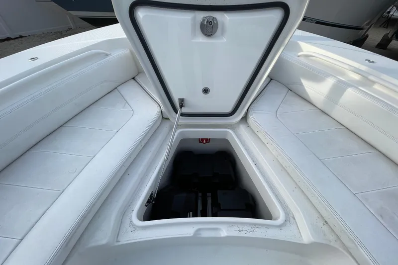 Slide: The Image of Open storage compartment on 2020 Regulator 26XO boat, featuring white cushioned seating. - 11