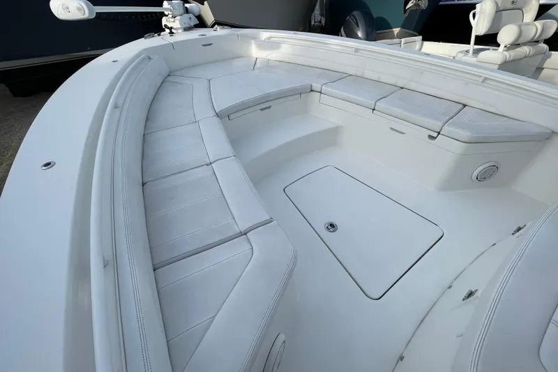 Slide: The Image of 2020 Regulator 26XO boat interior with white cushioned seating and storage compartments. - 13