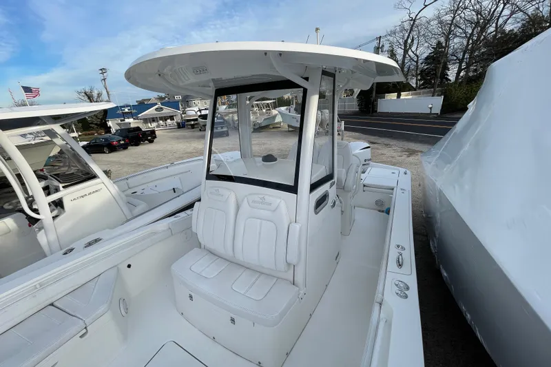 Slide: The Image of 2020 Regulator 26XO boat with T-top and seating, parked in a marina. - 16