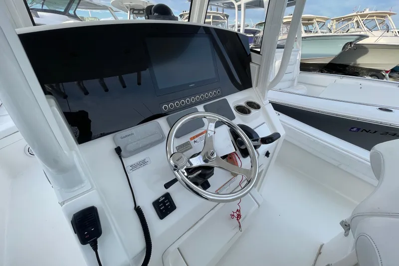 Slide: The Image of 2020 Regulator 26XO boat helm with steering wheel and navigation display. - 24