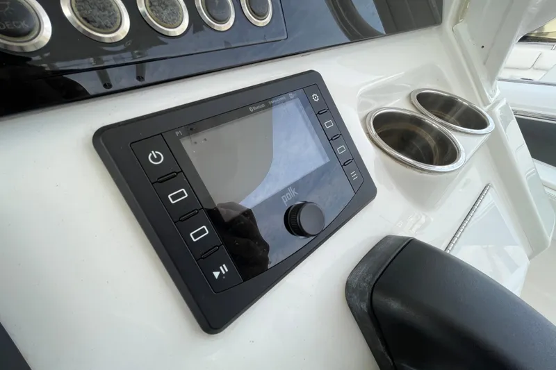 Slide: The Image of 2020 Regulator 26XO boat dashboard with Polk audio system and cup holders. - 27
