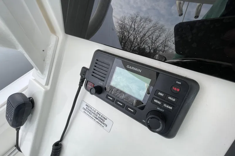Slide: The Image of Garmin marine radio on 2020 Regulator 26XO boat dashboard, with reflection of trees. - 29
