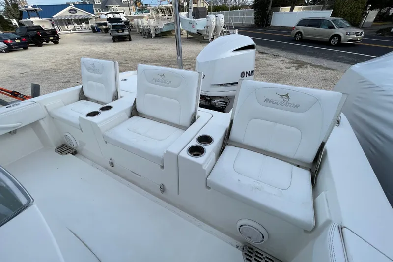 Slide: The Image of 2020 Regulator 26XO boat with white seating and Yamaha engine in a marina setting. - 31