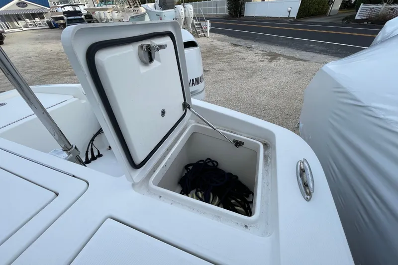Slide: The Image of 2020 Regulator 26XO boat storage compartment with open lid, showing ropes inside. - 35