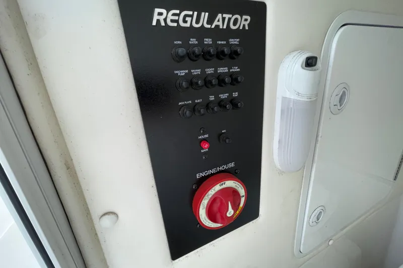 Slide: The Image of Control panel of a 2020 Regulator 26XO boat with various switches and dials. - 36