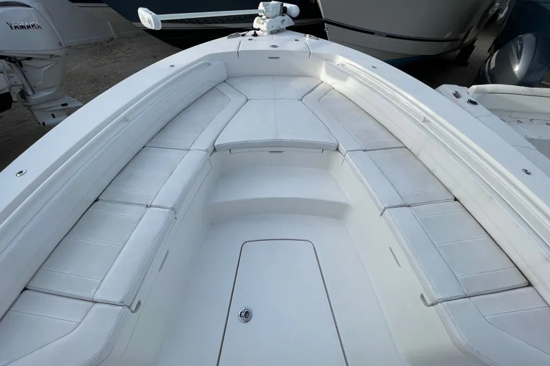 Slide: The Image of 2020 Regulator 26XO boat interior with white cushioned seating and storage compartments. - 8