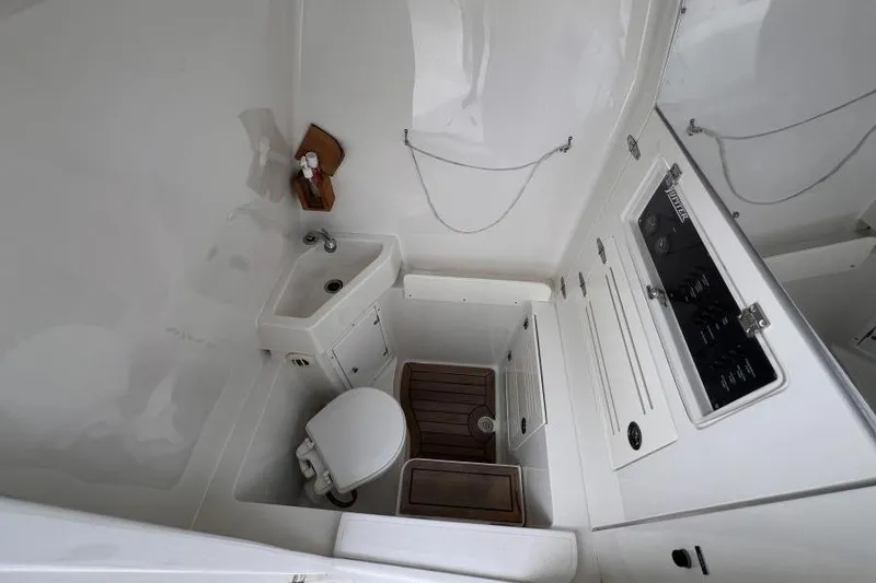 Slide: The Image of 2013 Jupiter 38 Cuddy boat bathroom with sink, toilet, and storage cabinets. - 7