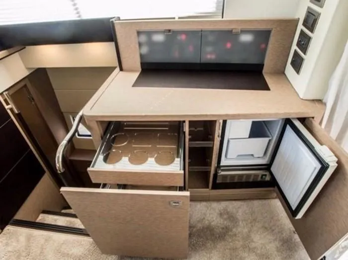 Slide: The Image of 2016 Prestige 560 yacht kitchen interior with open cabinets. - 10