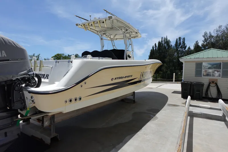 Slide: The Image of 2005 Hydra-Sports Vector 3300 CC boat on trailer, parked near a small building. - 2