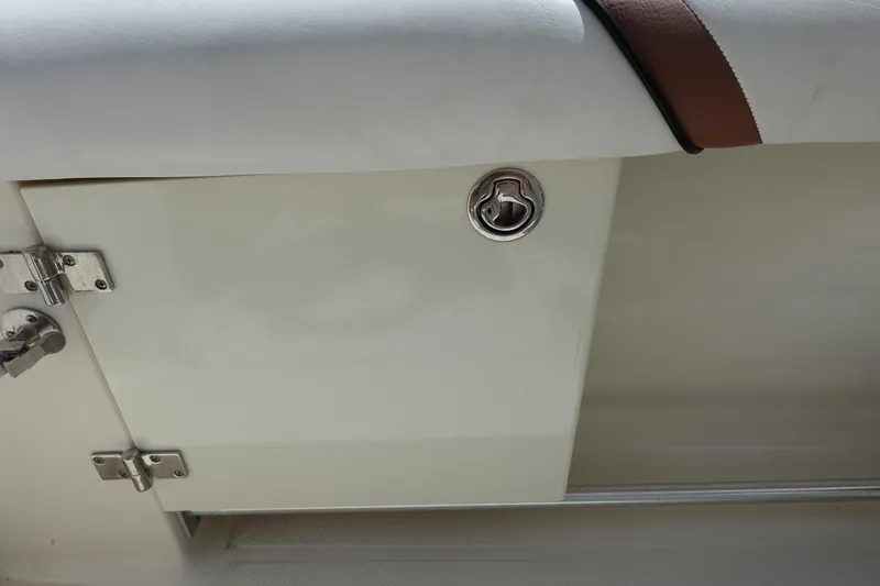 Slide: The Image of 2005 Hydra-Sports Vector 3300 CC boat compartment with stainless steel latch and white cushioned seat. - 22