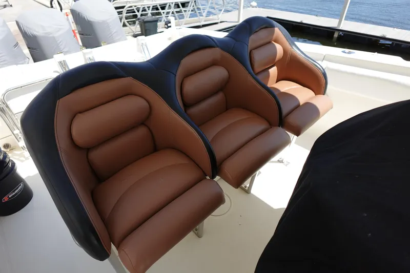 Slide: The Image of 2005 Hydra-Sports Vector 3300 CC boat seats, brown and black leather, docked by the water. - 28