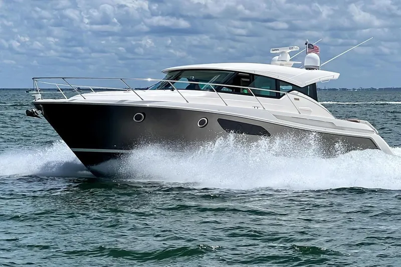 Slide: The Image of 2016 Tiara Yachts C44 Coupe cruising on open water under a cloudy sky. - 22