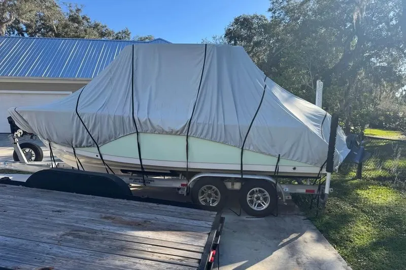 Slide: The Image of 2022 Sportsman Heritage 231 Center Console boat covered on trailer in driveway. - 3