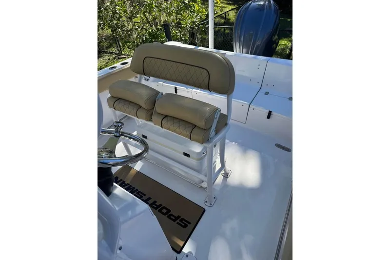Slide: The Image of 2022 Sportsman Heritage 231 Center Console boat interior with beige seating and steering wheel. - 7