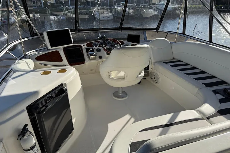 Slide: The Image of 2005 Meridian 459 Motoryacht cockpit with helm, seating, and marina view. - 12