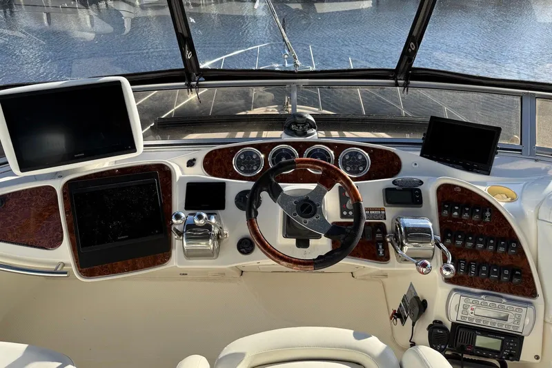 Slide: The Image of 2005 Meridian 459 Motoryacht helm with navigation screens and controls, overlooking water. - 13