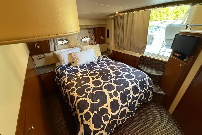 Slide: The Image of Luxurious bedroom interior of 2005 Meridian 459 Motoryacht with patterned bedding and porthole windows. - 28