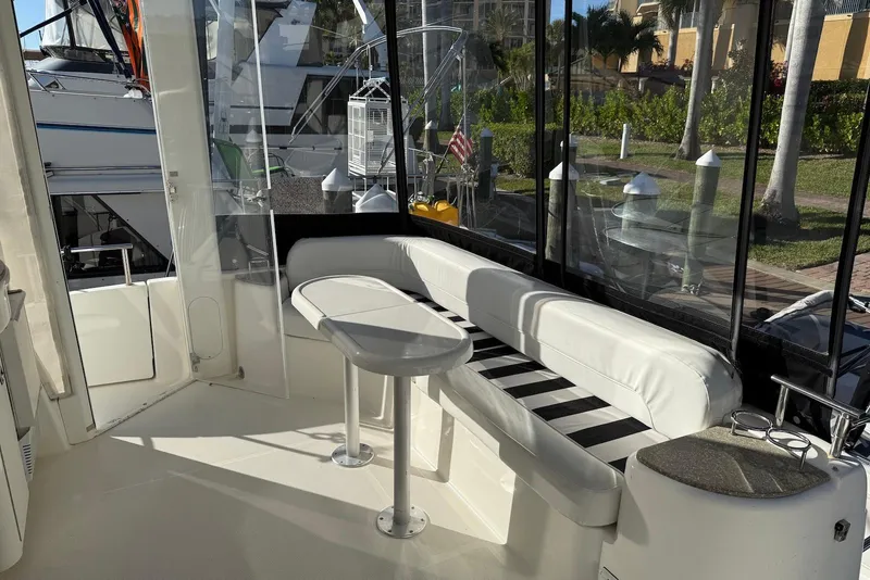 Slide: The Image of 2005 Meridian 459 Motoryacht interior with white seating and table, docked at marina. - 9
