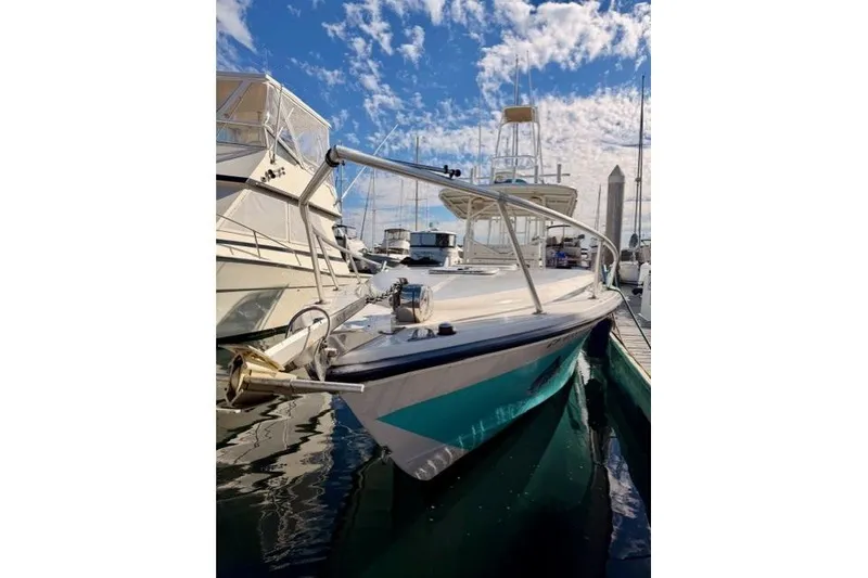 Slide: The Image of 1997 Marlin Yachts 350SF docked under a vibrant blue sky. - 2