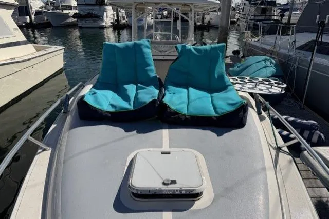 Slide: The Image of 1997 Marlin Yachts 350SF with blue deck chairs at marina. - 4