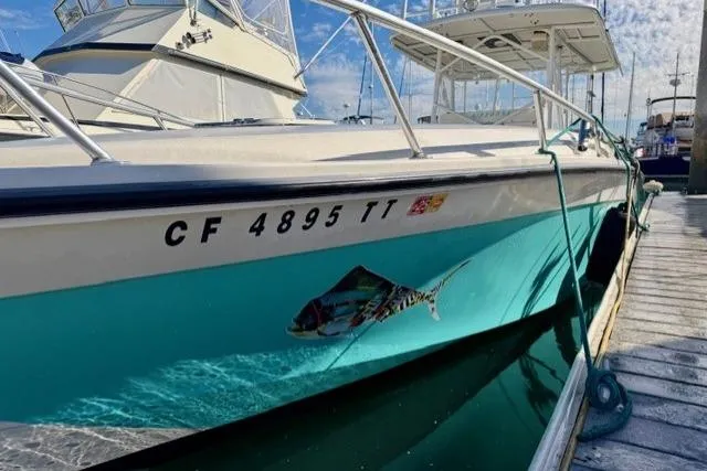 Slide: The Image of 1997 Marlin Yachts 350SF docked, featuring vibrant hull design and registration number. - 5