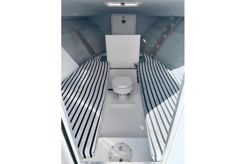 Slide: The Image of Interior cabin of 1997 Marlin Yachts 350SF with striped cushions and a toilet. - 7