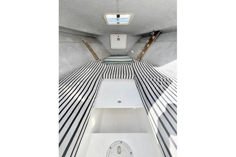 Slide: The Image of Interior cabin of 1997 Marlin Yachts 350SF with striped bedding and skylight. - 8