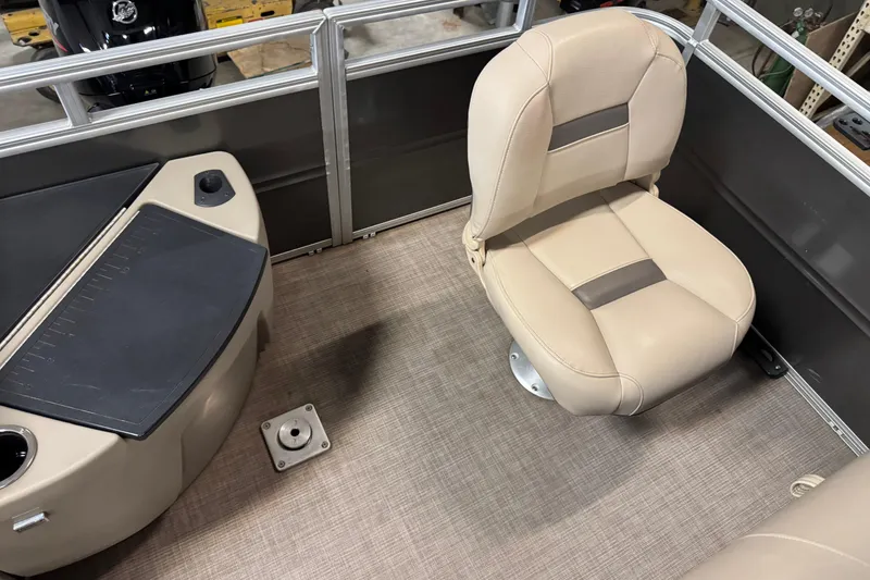Slide: The Image of 2024 Sun Tracker Fishin' Barge 20 DLX interior with beige seating and fishing station. - 18