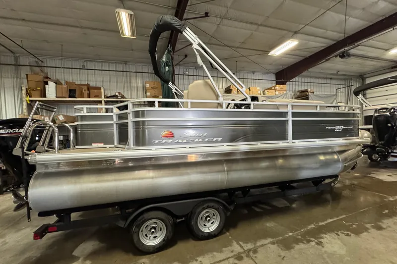 Slide: The Image of 2024 Sun Tracker Fishin' Barge 20 DLX pontoon boat in indoor storage. - 3